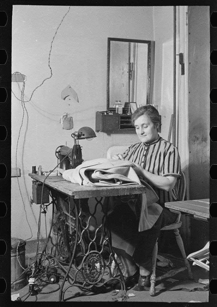 Историческое фото женщины, сидящей за швейной машинкой