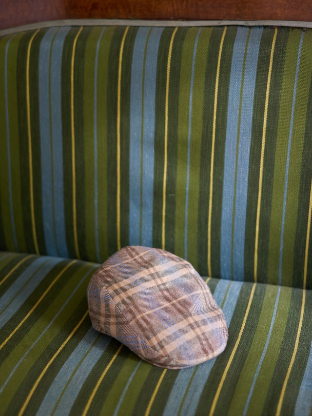 Фотография кепки на диванчике в сине-зеленую полоску