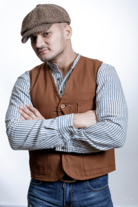 The man in Brown Canvas Hunting Vest Union of Friends and Brown Herringbone Tweed 8-piece Cap by Hanna Hats